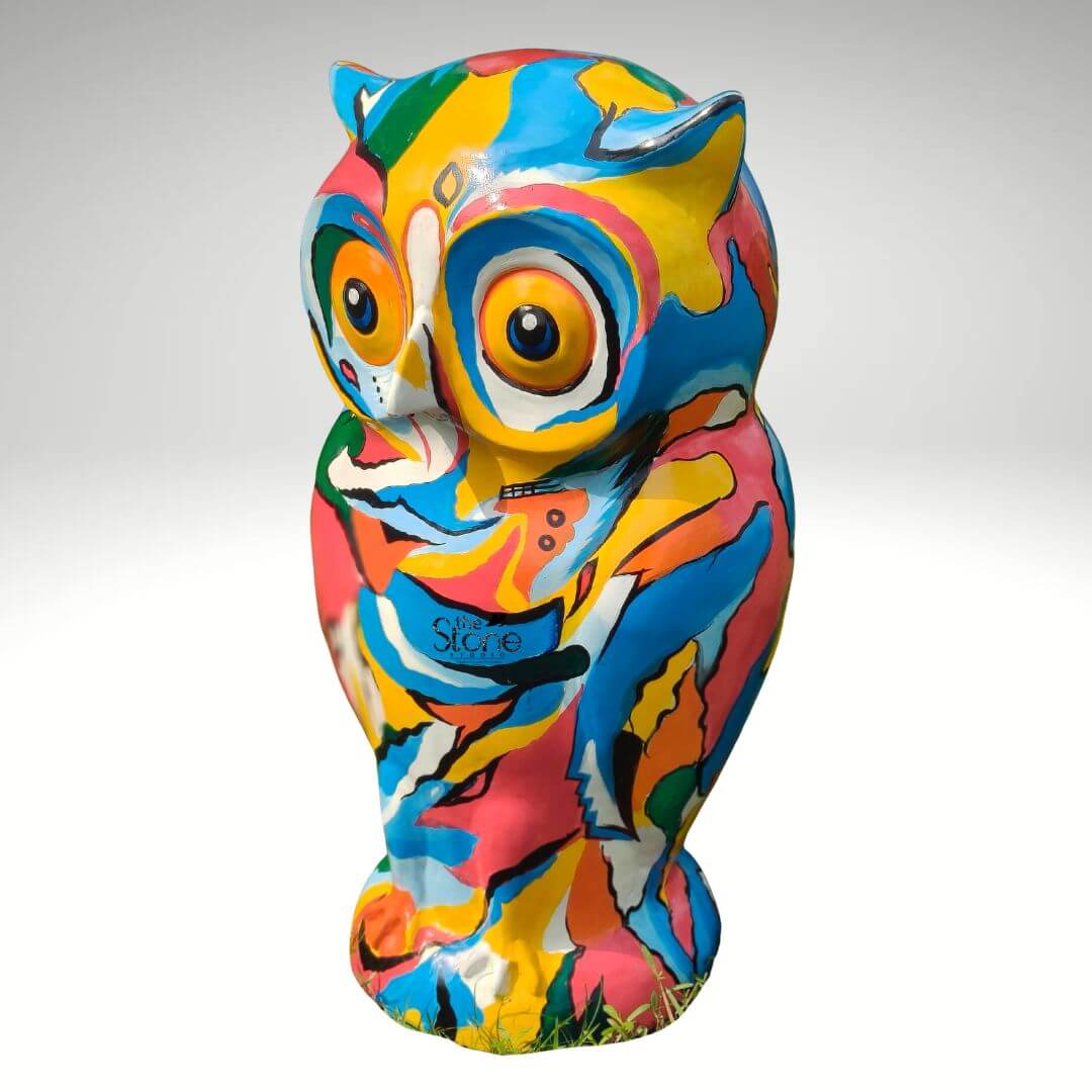 Pop Art Owl Statue 3ft 10 A vibrant three-foot-tall modern owl garden statue stands centered against a seamless light grey studio background. The sculpture is a dynamic example of Pop Art completely covered in a chaotic yet harmonious patchwork of bold abstract shapes and vivid clashing colors including hot pink turquoise blue bright yellow, orange and green. The paint is applied with sweeping energetic brushstrokes creating a fluid non-representational pattern that wraps entirely around the owl's form from its pointed ear tufts down to its integrated base. The overall aesthetic is playful and highly decorative. The statue is sculpted in a realistic standing owl pose featuring prominent ear tufts and large wide-set eyes that are intricately integrated into the abstract color scheme. The eyes have orange irises and dark pupils outlined in white to give them a captivating slightly whimsical gaze. The beak is suggested by the convergence of colored patches and the talons at the base are subtly defined with paint. The statue's durable fibre material is apparent providing a smooth matte finish that enhances the intensity of the colors. This 36-inch Fibre Pop Art Owl statue is specifically designed to be a striking garden accent. Its large scale and eye-catching multi-colored design make it an ideal focal point for modern outdoor spaces adding an artistic flair and a burst of color to landscaping patios or flower beds. The statue's modern interpretation of a classic garden ornament perfectly embodies the spirit of contemporary accessible art designed to engage and delight. Its sturdy construction ensures it is both a decorative piece and a conversation starter in any garden setting.