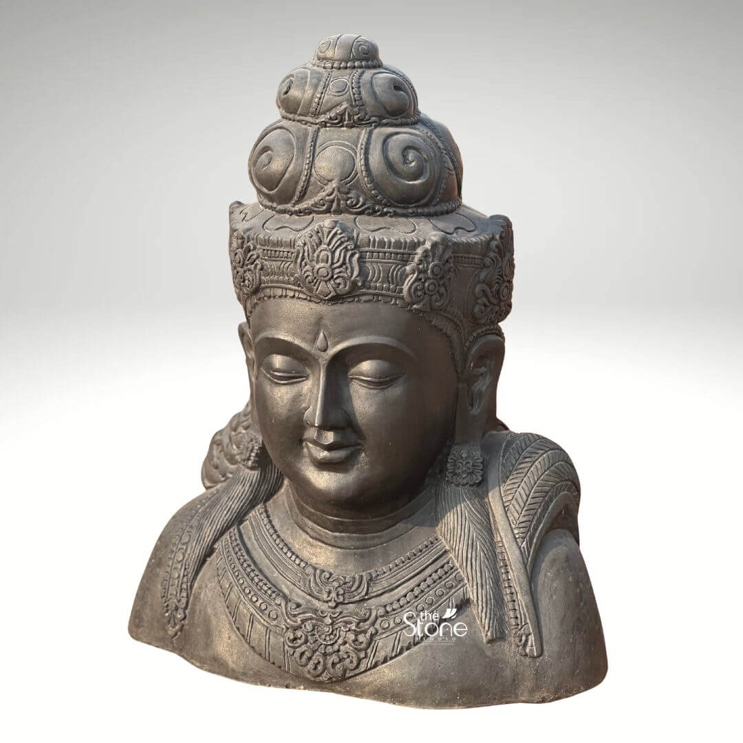 Shiva Bust Statue 30" 9 A captivating 2.5 Feet Blackstone Shiva Bust Statue ideal for tranquil Garden Decor is prominently displayed against a clean light background highlighting its rich details and profound presence. This exquisite sculpture carved from dark blackstone depicts Lord Shivas head and upper torso exuding a sense of ancient wisdom and serenity. His eyes are gently closed in deep meditation conveying a timeless tranquility that makes it a perfect piece for a contemplative outdoor space. The smooth polished surface of the blackstone reflects light softly accentuating the contours of his serene face and the intricate carvings. Shiva is adorned with an elaborate crown meticulously designed with traditional swirls and motifs that signify his divine and regal status. His hair is styled in a jatamukuta a coiled ascetic's bun adding to his iconic representation. Beneath the crown delicate decorative bands encircle his forehead. His face features a composed expression with full lips and defined features, evoking profound peace. Along his chest intricately carved necklaces and chest plates are visible showcasing traditional artistry, making this Shiva Head for Garden Decor a statement piece. The dark tone of the blackstone provides a striking contrast against any greenery enhancing its visual impact in a garden setting. The bust extends to the upper chest revealing detailed adornments and subtle indications of flowing garments over broad shoulders conveying divine strength and presence. The overall craftsmanship of the 2.5 Feet Blackstone Shiva Bust Statue is exceptional offering both aesthetic beauty and spiritual depth. This detailed description effectively connects the visual elements of the blackstone bust with its suitability for garden decor emphasizing its ability to create a serene and meditative atmosphere in an outdoor environment.