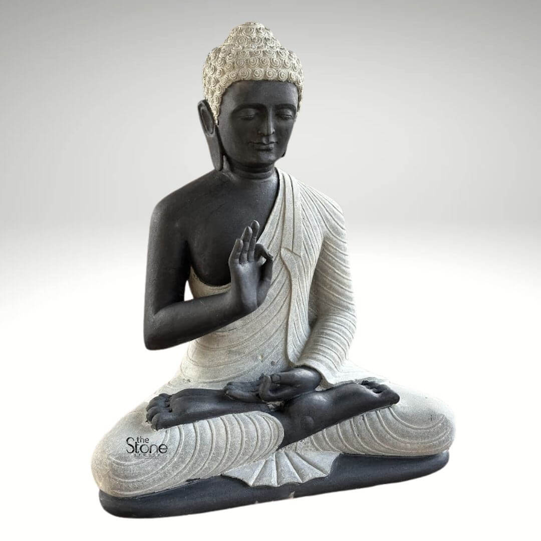 2.5ft Buddha Sculpture for Garden 7 A captivating 2.5-foot garden Buddha statue meticulously crafted from black stone with elegant white accents depicted in a classic meditative posture as featured in an article about garden Buddha statues. The statue presents the Buddha seated cross-legged with his right hand raised in the Vitarka Mudra and his left hand resting in his lap in the Dhyana Mudra. The body is sculpted from a dark almost black stone providing a strong grounding presence while his robes and the tightly curled hair on his head are rendered in a contrasting lighter off-white or grey stone highlighting these features. The robes are intricately carved with flowing realistic folds and pleats suggesting the soft drape of fabric adding a sense of serenity and refined detail to the sculpture. The Buddha's face is characterized by a calm and contemplative expression with downcast eyes a gentle nose and subtle lips embodying profound inner peace and enlightenment. The tightly curled hair a distinctive iconographic feature is intricately textured in the lighter stone adding depth and authenticity. His elongated earlobes another symbolic feature are also clearly visible. The overall design of this 2.5-foot black stone Buddha statue showcases a harmonious blend of two contrasting stone colors enhancing its visual appeal and artistic merit. The smooth contours and fine details throughout the sculpture emphasize a deep sense of tranquility and spiritual harmony making it an ideal piece for creating a peaceful and reflective corner in any garden. This statue perfectly aligns with the article's theme of garden Buddha statues offering both aesthetic beauty and a spiritual focal point for outdoor spaces.