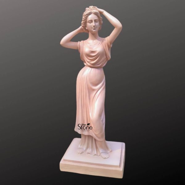 An elegant and life-sized 5.5-foot Lady Statue, meticulously crafted from durable fibre, designed for luxury resort and hotel landscapes. The classical female figure is depicted in a graceful posture, adjusting her hair with both hands, conveying a sense of timeless serenity. She is clad in floor-length Grecian-style drapery with masterfully sculpted flowing folds that suggest movement. The statue has a smooth, pale terracotta-toned finish, making it a sophisticated addition to outdoor garden spaces, hotel lobbies, or grand entryways. Standing firmly on a matching square tiered base, this angelic-styled fibre statue is both lightweight and weather-resistant, perfect for enhancing the aesthetic appeal of high-end commercial properties.