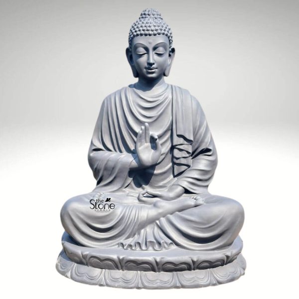 A majestic 65-inch tall Lord Buddha statue expertly crafted from premium fibre material, serving as a profound spiritual centerpiece for indoor or outdoor spaces. The sculpture depicts Lord Buddha in a serene seated meditation posture atop a beautifully hand-carved, multi-layered lotus pedestal. His right hand is raised in the sacred Abhaya Mudra, a universal gesture of protection, peace, and fearlessness, while his left hand rests calmly in his lap. The fibre Buddha statue features a sophisticated matte grey finish that flawlessly mimics the texture and weight of natural stone, making it both durable and weather-resistant. Masterful craftsmanship is visible in the fine details of the deity’s serene facial expression, elongated earlobes, and the realistic, fluid folds of his monastic robes. Standing at over five feet, this large-scale Abhaya Mudra Buddha sculpture is designed to invite tranquility and mindfulness into grand home gardens, office foyers, or meditation sanctuaries, perfectly blending traditional Vedic iconography with modern, long-lasting materials.