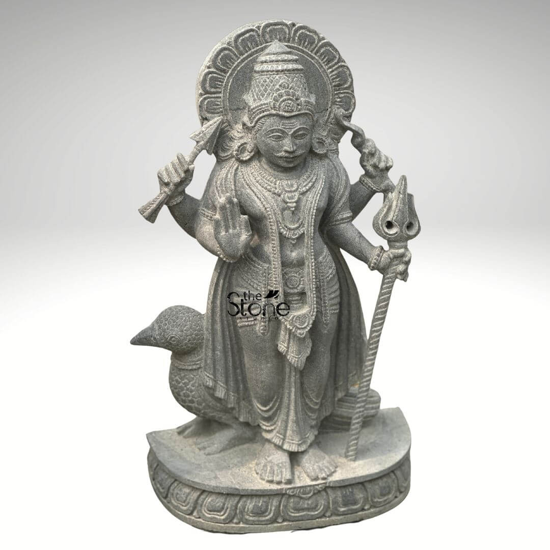 Shani Dev Stone Statue with Crow 27" 2 An exquisitely handcrafted 27-inch Shani Dev murti masterfully hand-carved from premium natural blackstone to serve as a powerful spiritual centerpiece. The sculpture depicts Shani Dev the lord of justice and the planet Saturn in a majestic standing posture atop a circular lotus pedestal. The deity is portrayed with four arms holding sacred symbols his upper hands hold a traditional bow and arrow while his lower right hand is raised in the Abhaya Mudra the universal gesture of protection and blessing. His lower left hand rests firmly on an ornate Gada (mace). Standing faithfully behind his right foot is the crow, his divine vehicle or vahana masterfully carved with lifelike precision. The craftsmanship showcases incredible detail, from the towering tiered mukut and expressive facial features with a traditional mustache to the layered necklaces and realistic fabric folds of his attire. Framing the head is a grand, circular Prabhavali embellished with rhythmic relief patterns. The refined matte charcoal finish of the stone highlights the heritage of traditional Indian stone masonry making this Shani dev statue an ideal addition to a home mandir or personal altar to invite discipline, stability, and divine protection into the living space.