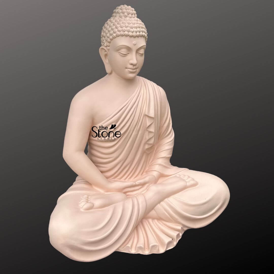 Buddha Statue for Home Decor 4 Feet 8 A serene 4-foot fiber Buddha statue, ideal for indoor decoration is presented from a frontal slightly elevated perspective against a plain dark background. The statue is crafted from a light possibly off-white or very pale pink fiber giving it a smooth and soft aesthetic that perfectly suits a calming interior space. Buddha is depicted in a profound seated meditation posture with his legs crossed and his hands resting gently in his lap palms facing upwards likely in Dhyana Mudra. Buddha's face exudes tranquility with downcast eyes and a subtle smile embodying deep inner peace and contemplation. His hair is composed of tight, uniform curls, meticulously carved, and topped with an ushnisha, symbolizing heightened spiritual wisdom. The flowing robes are sculpted with soft, graceful folds, elegantly draping over his left shoulder and across his body, revealing his right shoulder. The smooth finish of the fiber material highlights every detail of his serene form, from the delicate curves of his features to the naturalistic drapery of his robe. The statue appears to rest directly on a flat surface, with no separate base visible, emphasizing its grounded presence. This detailed image effectively conveys the spiritual essence and artistic craftsmanship of the fiber Buddha statue, making it highly relevant to an article discussing large Buddha statues for indoor decoration.