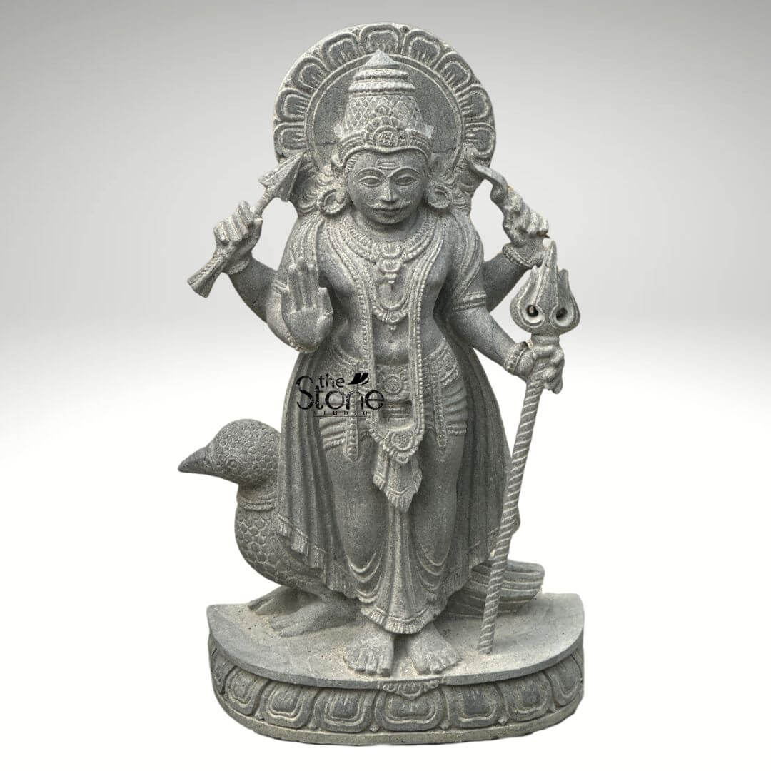 Shani Dev Stone Statue with Crow 27" 4 An exquisitely hand-carved 27-inch Lord Shani Dev stone idol masterfully sculpted from premium natural blackstone with a refined rustic matte finish. The deity, known as the lord of justice and the planet Saturn, is depicted in a majestic standing posture atop a circular lotus pedestal. Lord Shani is portrayed with four arms carrying sacred spiritual symbols: his upper hands hold a traditional bow and arrow while his lower right hand is raised in the Abhaya Mudra, the universal gesture of protection and fearlessness. His lower left hand rests firmly on an ornate Gada . Standing faithfully behind his right leg is the crow, his divine vehicle or vahana, carved with lifelike precision into the stone. The craftsmanship highlights incredible detail from the towering, tiered mukut and expressive facial features to the intricate layered necklaces and the realistic, fluid folds of his traditional attire. Framing the deity's head is a grand, circular Prabhavali embellished with rhythmic relief patterns that represent a divine aura. This durable and timeless 2.25-foot blackstone Shani Dev statue is an ideal spiritual centerpiece for a home mandir or personal altar, designed to invite discipline, stability, and divine protection into any environment.
