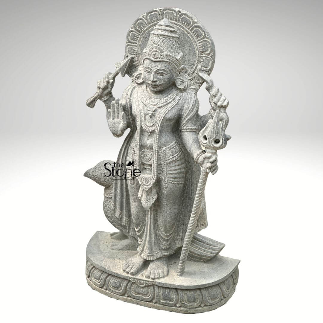 Shani Dev Stone Statue with Crow 27" 5 An exquisitely hand-carved 27-inch Lord Shani Dev stone idol masterfully sculpted in a traditional temple style from premium natural blackstone. The sculpture depicts Shani Dev the lord of justice and the planet Saturn in a majestic standing posture atop an intricately carved lotus pedestal. The deity is portrayed with four arms carrying sacred Vedic symbols: his upper hands hold a traditional bow and arrow while his lower right hand is raised in the Abhaya Mudra the universal gesture of protection and fearlessness. His lower left hand rests firmly on an ornate Gada (mace) Standing faithfully behind his right leg is his divine vehicle, the crow carved with lifelike precision to complete the authentic spiritual iconography. The craftsmanship showcases exceptional detail, from the towering, tiered mukut (crown) and expressive facial features to the layered necklaces and realistic fluid fabric folds of his traditional dhoti. Framing the head is a grand, circular Prabhavali (ornate arch) embellished with rhythmic, shell-like relief patterns that represent a divine halo. The refined matte grey-black finish of the stone highlights the heritage of traditional Indian stone masonry making this Shani Dev statue an ideal spiritual centerpiece for a home mandir, garden sanctuary, or personal altar, designed to invite discipline, stability, and divine protection into any environment.