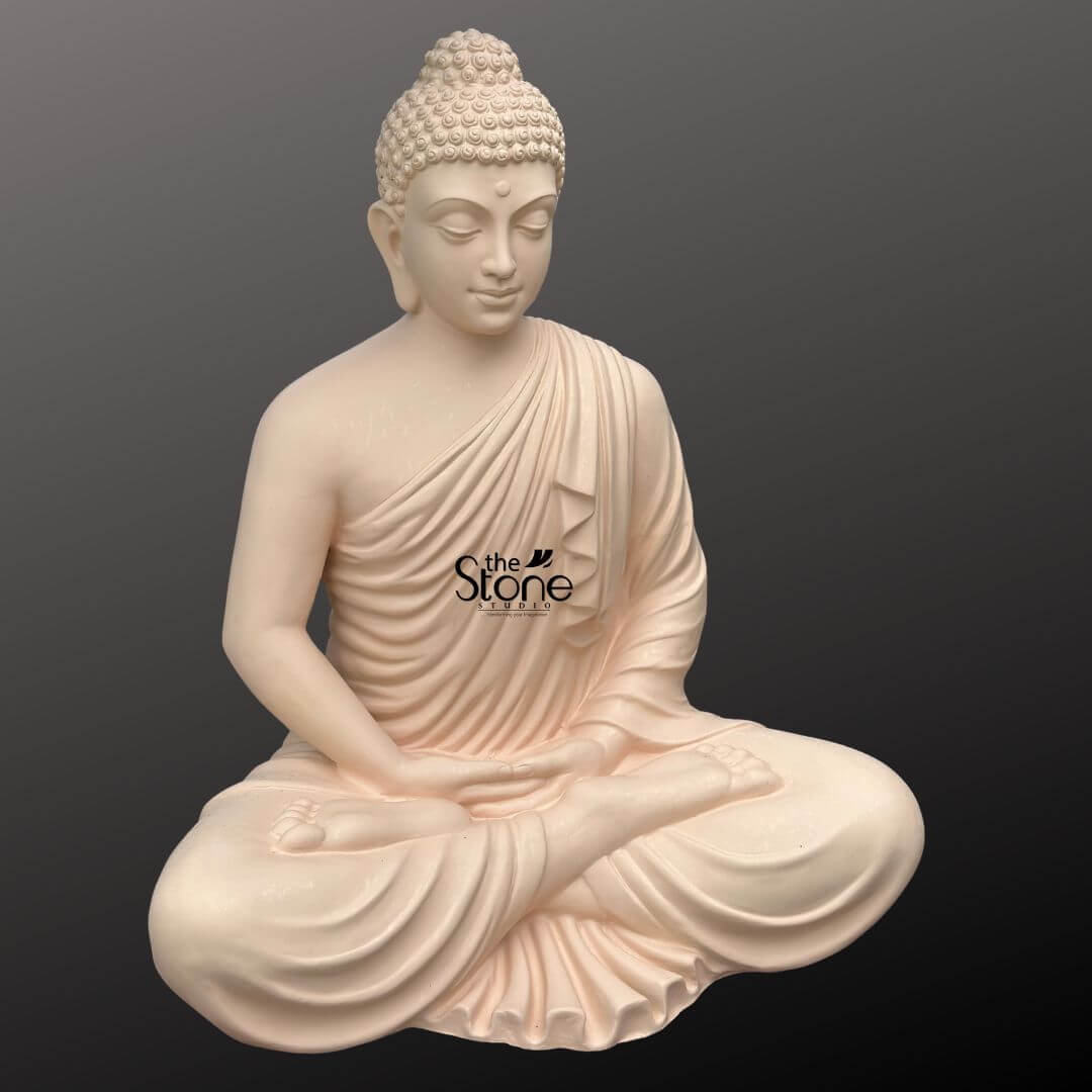 Buddha Statue for Home Decor 4 Feet 10 A serene 4-foot fiber Buddha statue ideal for meditation spaces is presented from a frontal slightly elevated perspective against a plain dark background. The statue is crafted from a light possibly very pale pink fiber, giving it a smooth and soft aesthetic that promotes tranquility. Buddha is depicted in a profound seated meditation posture with his legs crossed and his hands resting gently in his lap, palms facing upwards, likely in Dhyana Mudra. Buddha's face exudes deep tranquility, with downcast eyes and a subtle smile, embodying inner peace and contemplative calm. His hair is composed of tight, uniform curls, meticulously carved, and topped with an ushnisha, symbolizing heightened spiritual wisdom. The flowing robes are sculpted with soft, graceful folds, elegantly draping over his left shoulder and across his body, revealing his right shoulder. The smooth finish of the fiber material highlights every detail of his serene form, from the delicate curves of his features to the naturalistic drapery of his robe. The statue appears to rest directly on a flat surface, with no separate base visible, emphasizing its grounded presence. This detailed image effectively conveys the spiritual essence and artistic craftsmanship of the fiber Buddha statue, making it highly relevant to an article discussing meditation Buddha statues.