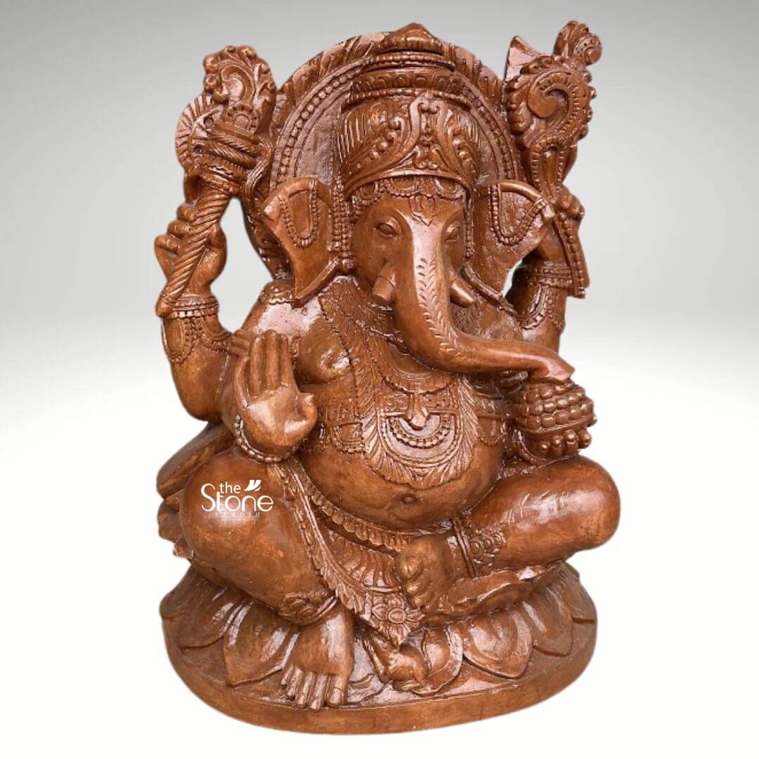Pillaiyar Ganesha Statue 2.5ft 7 An exquisitely hand-carved 2.5-foot tall Lord Ganesha statue masterfully sculpted from premium natural brown sandstone. This large-scale spiritual masterpiece depicts the deity in an auspicious and stable seated posture atop an intricately detailed, multi-tiered lotus pedestal which symbolizes purity and spiritual grounding. Lord Ganesha is portrayed with his iconic elephant head, featuring a serene facial expression, a gracefully curved trunk, and large ears that represent the wisdom of listening. The deity has four arms carrying sacred Vedic symbols: his upper hands hold the pasha and ankusha to guide and remove obstacles while his lower right hand is raised in the Abhaya Mudra the universal gesture of protection and blessing. The craftsmanship highlights incredible artisan detail from the towering, tiered mukut and layered necklaces to the armlets and realistic fabric folds of his traditional attire. The refined matte finish and grainy, earthy reddish-brown texture of the sandstone highlight the heritage of traditional Indian stone masonry, making this 30-inch Ganesha idol a perfect addition to invite peace, prosperity, and divine stability into a home mandir, grand foyer, or garden landscape.