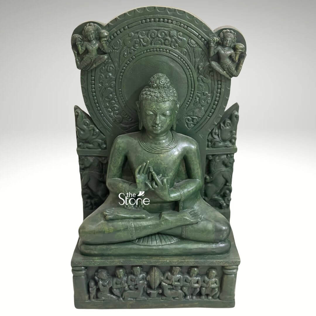 Meditation Buddha Statue 2ft 5 A deeply spiritual 2-foot green stone Buddha statue ideal for sacred meditation spaces is presented from a slightly elevated frontal perspective against a plain light background. The statue is entirely carved from green stone providing a unique and ancient aesthetic. Buddha is depicted in a traditional seated meditation posture with his legs crossed. His hands are positioned in a mudra (symbolic gesture), likely Dharmachakra Mudra, signifying the turning of the Wheel of Dharma or teaching. His eyes are gently downcast conveying profound introspection, peace, and concentration. His hair is composed of tight, uniform curls, topped with an ushnisha symbolizing wisdom. The Buddha is seated on a multi-tiered base. The uppermost tier is a simple platform, while the lower, rectangular pedestal is richly adorned with a frieze of smaller figures possibly disciples or devotees, seated in reverence. Behind the Buddha's head rises an elaborate circular prabhavali (halo) with intricate carvings of floral patterns and possibly celestial beings. On either side of the prabhavali winged figures or deities are depicted adding to the divine and ethereal aura. The textured surface of the green stone highlights the intricate details of all the carvings, from the delicate features of the Buddha to the elaborate motifs on the backdrop and base. This detailed image powerfully conveys the sacred and artistic craftsmanship of the green stone Buddha statue, making it highly relevant to an article discussing meditation statues.
