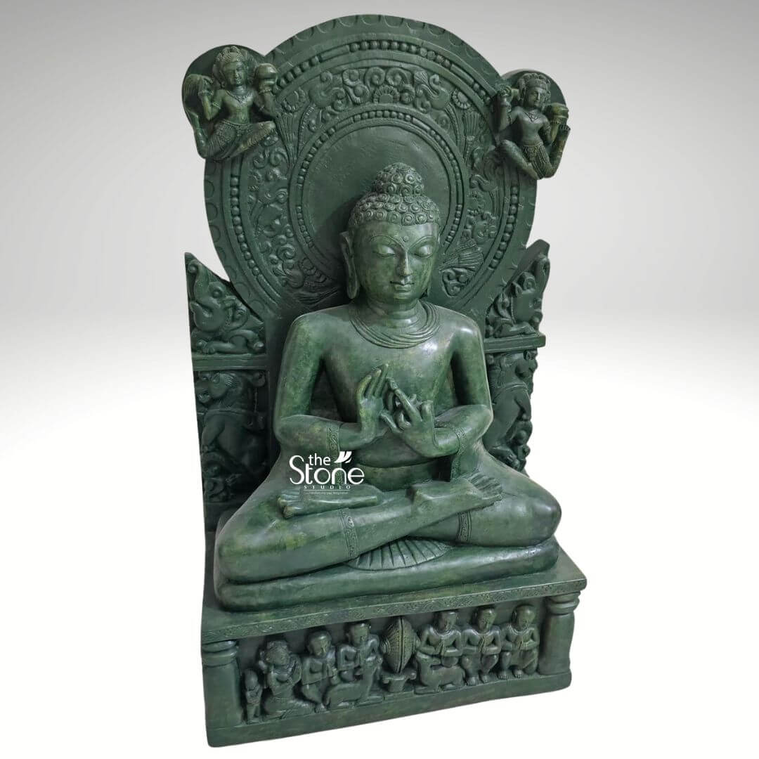 Meditation Buddha Statue 2ft 7 A magnificent 2-foot green stone statue titled The Enlightened Buddha Sculpture is presented from a slightly elevated frontal perspective against a plain light background. The statue is entirely carved from a deep green stone imbuing it with an ancient revered aesthetic. Buddha is depicted in a profound seated meditation posture with his legs crossed. His hands are positioned in a mudra likely Dharmachakra Mudra signifying the moment of teaching and enlightenment. His eyes are gently downcast, conveying deep introspection, ultimate peace, and the state of enlightenment. His hair is composed of tight, uniform curls, meticulously carved, and topped with an ushnisha a symbol of his expanded wisdom. The Buddha is seated on a multi-tiered base. The uppermost tier is a simple platform, while the lower, rectangular pedestal is richly adorned with a frieze of smaller figures, possibly disciples or devotees, seated in various postures of reverence. Behind the Buddha's head rises an elaborate, circular prabhavali featuring intricate carvings of swirling patterns and possibly auspicious symbols. On either side of the prabhavali winged celestial figures or deities are depicted, adding to the divine and ethereal atmosphere surrounding the Enlightened One. The natural texture of the green stone accentuates the intricate details of all the carvings, from the delicate features of the Buddha to the elaborate motifs on the backdrop and base. This detailed image powerfully conveys the spiritual majesty and artistic craftsmanship of the green stone Buddha statue making it highly relevant to an article discussing an enlightened Buddha sculpture.