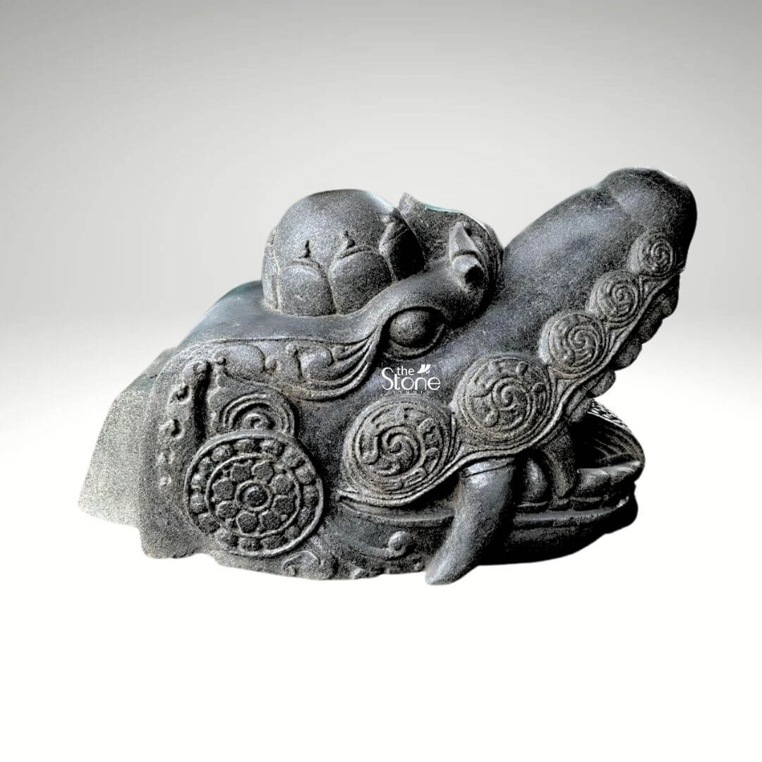 Dragon Head Statue 18" 5 A magnificent black stone dragon head idol meticulously carved to a length of 1.5 feet and a height of 1 foot is presented against a stark white background emphasizing its intricate details and powerful presence. This sculpture is specifically designed as a significant idol or decorative element for an entrance embodying traditional protective symbolism. The dragon's head is depicted with a robust and dynamic snout its mouth slightly open to reveal stylized fangs and a textured interior conveying a sense of alertness and guardianship. The dark rich black stone lends the idol an ancient, enduring quality making it suitable for both outdoor and prominent indoor placements. The entire surface of the dragon's head is richly adorned with traditional flowing carved patterns including swirling motifs that suggest the intricate texture of scales or mystical energies. Prominent circular designs reminiscent of ancient symbols or stylized floral patterns are integrated into the ornamentation adding layers of cultural depth and aesthetic appeal. The eyes are deeply set and carved with a focused intense gaze, which enhances the protective and vigilant aura of the dragon. A distinctive crown-like or horn-like protrusion on the top of the head further establishes its majestic and mythical status reinforcing its symbolic power as an idol. The craftsmanship is evident in the varied textures across the sculpture from the smoother more refined areas to the rugged detailed scales and ridges along the jawline and brow. This interplay of textures creates a dynamic visual effect, allowing light and shadow to highlight the three-dimensional form and bring the mythical creature to life. This blackstone dragon head idol is not merely a decorative piece; it serves as a powerful cultural and spiritual artifact symbolizing strength prosperity, and protection, making it an ideal inclusion in an article discussing dragon head idols for entrances intended to bless and safeguard the space.