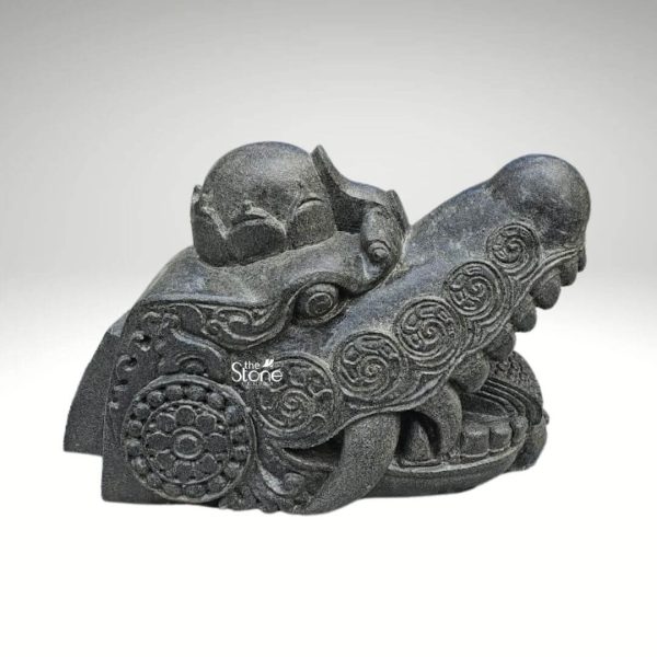 A striking black stone dragon head statue measuring 1.5 feet in depth and 1 foot in height is presented against a plain background highlighting its intricate carvings and formidable presence. The sculpture captures the fierce and mystical essence of a dragon with its powerful snout and open mouth revealing menacing fangs. The texture of the black stone with its natural variations and subtle sheen enhances the ancient and weathered appearance of the mythical creature. The dragon's head is adorned with elaborate swirling patterns carved into the stone characteristic of traditional Asian dragon iconography. Circular motifs resembling ancient coins or floral designs are intricately integrated into the broader decorative scheme adding a layer of cultural depth to the piece. The eyes though stylized convey an intense gaze while the brow is furrowed suggesting a creature of immense power and wisdom. On the top of the head a small crown-like protrusion or perhaps a horn is visible further emphasizing its regal and mythical status. The craftsmanship is evident in the finely detailed scales and ridged textures that delineate the dragon's features from its snout to the back of its head. The contours are smooth in some areas and rugged in others, creating a dynamic interplay of light and shadow that accentuates the three-dimensional form. This blackstone dragon head statue is not merely a decorative item but a piece of art that embodies strength protection, and ancient folklore making it an ideal subject for an article discussing such unique and culturally rich sculptures. Its size and material suggest it could be a significant architectural element, a garden ornament or a substantial display piece in a collection.
