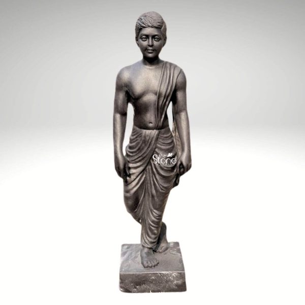 A finely crafted three-foot black stone statue of an Indian village boy stands gracefully against a plain white background highlighting its realistic details and cultural charm. The statue, central to an article about such traditional sculptures depicts a young boy in a natural walking pose with one foot slightly lifted as if in mid-stride. He is clad in simple flowing traditional Indian attire a dhoti draped expertly around his waist and legs with naturalistic folds that convey movement and lightweight fabric. A shawl or upper garment is draped over his left shoulder adding to the authenticity of the village attire. The craftsmanship is evident in the detailed sculpting of the boy's features. His face is youthful and expressive with serene eyes a gentle nose and finely carved lips reflecting an innocent and calm demeanor. His hair is neatly styled and sculpted adding to the lifelike quality of the figure. The sculptor has paid attention to anatomical details showing subtle musculature and realistic proportions for a young boy. The texture of the black stone with its inherent depth and subtle sheen enhances the statue's aesthetic appeal giving it a timeless and dignified presence. The boy stands barefoot on a sturdy square black stone base which provides stability and elevates the sculpture. The overall impression is one of simplicity grace, and cultural representation making it a compelling piece for a garden a traditional home or an art collection. This three-foot blackstone Indian village boy statue is a beautiful artistic tribute to rural life and traditional Indian culture ideal for display in settings that appreciate historical or cultural themes.