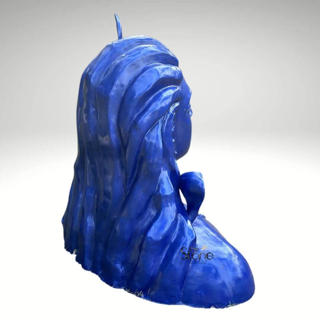 Blue Adiyogi Shiva Statue 4ft 12 A striking 4-foot fiber Adiyogi Shiva idol is presented from a rear side profile against a plain background making it an evocative piece for a meditation space. The sculpture captures the upper torso and head of Lord Shiva in his Adiyogi form depicted with closed eyes in deep meditation though not fully visible from this angle. conveying profound inner peace. From this perspective the voluminous matted locks are prominently displayed styled upwards and flowing down his back and shoulders, with a subtle crescent moon visible at the top symbolizing his ascetic nature. The entire statue is rendered in a vibrant deep blue color characteristic of Shiva's divine complexion. The detailing on his hair which is sculpted with flowing lines and distinct texture showcases remarkable artistry even from the back. The smooth, glossy finish of the fiber material enhances the statue's vibrant blue hue, making it a visually captivating piece that evokes both ancient reverence and modern artistic interpretation. The robust fiber construction ensures the statue is durable yet relatively lightweight suitable for various indoor and outdoor settings, including a dedicated meditation space. While the intricate facial features are not the focus from this angle, the powerful silhouette and the dramatic flow of the hair contribute to the statue's commanding presence. A small part of the serpent around his neck is subtly visible. This 4-foot fiber Adiyogi Shiva idol truly embodies spiritual power and artistic grace with its intense blue color adding to its mystique. Its commanding yet tranquil presence makes it a powerful symbol of yoga and ultimate liberation perfect for inspiring meditation and reverence in a sacred space.