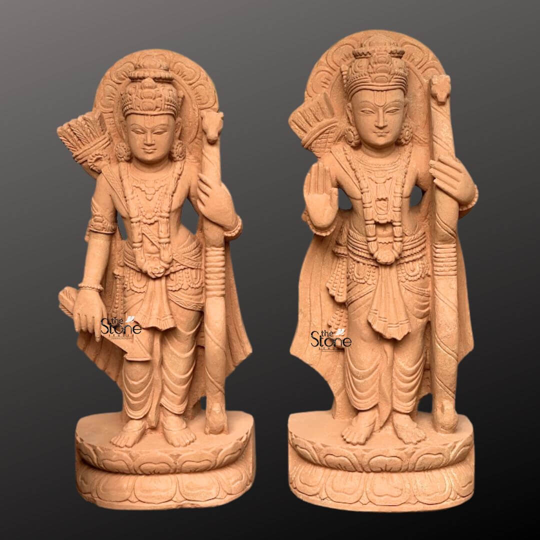 Ram Darbar Idol for Home Temple 2ft 6 A pair of exquisite 2-foot handcrafted sandstone statues of Lord Rama and Lakshmana from a Ram Darbar set are elegantly displayed against a dark gradient background. Both deities stand in noble postures embodying grace and valor. Lord Rama on the right is depicted with his right hand raised in a gesture of blessing and holding his bow and arrow symbolizing protection and righteousness. Lakshmana on the left also holds his bow and arrow mirroring his brother's steadfastness. Each figure is adorned with elaborate crowns intricate jewelry and flowing traditional garments all meticulously carved from the warm earthy sandstone. Behind the heads of both Rama and Lakshmana circular halo-like structures are intricately carved with traditional patterns further accentuating their divine aura and significance. The craftsmanship is evident in every detail from the serene expressions on their faces to the delicate folds of their attire and the intricate patterns of their ornaments. The sandstone's natural texture and warm hue give the statues an authentic ancient feel enriching their spiritual presence and highlighting the artisans' skill. Each figure stands on a multi-layered circular base also carved from sandstone featuring delicate lotus petal motifs. These sturdy bases provide a strong aesthetic foundation and elevate the statues making them prominent display pieces. This pair of 2-foot handcrafted sandstone statues representing key figures of the Ram Darbar captures the essence of divine heroism and brotherly loyalty making them a captivating subject for an article exploring such intricately crafted and spiritually significant sculptures.