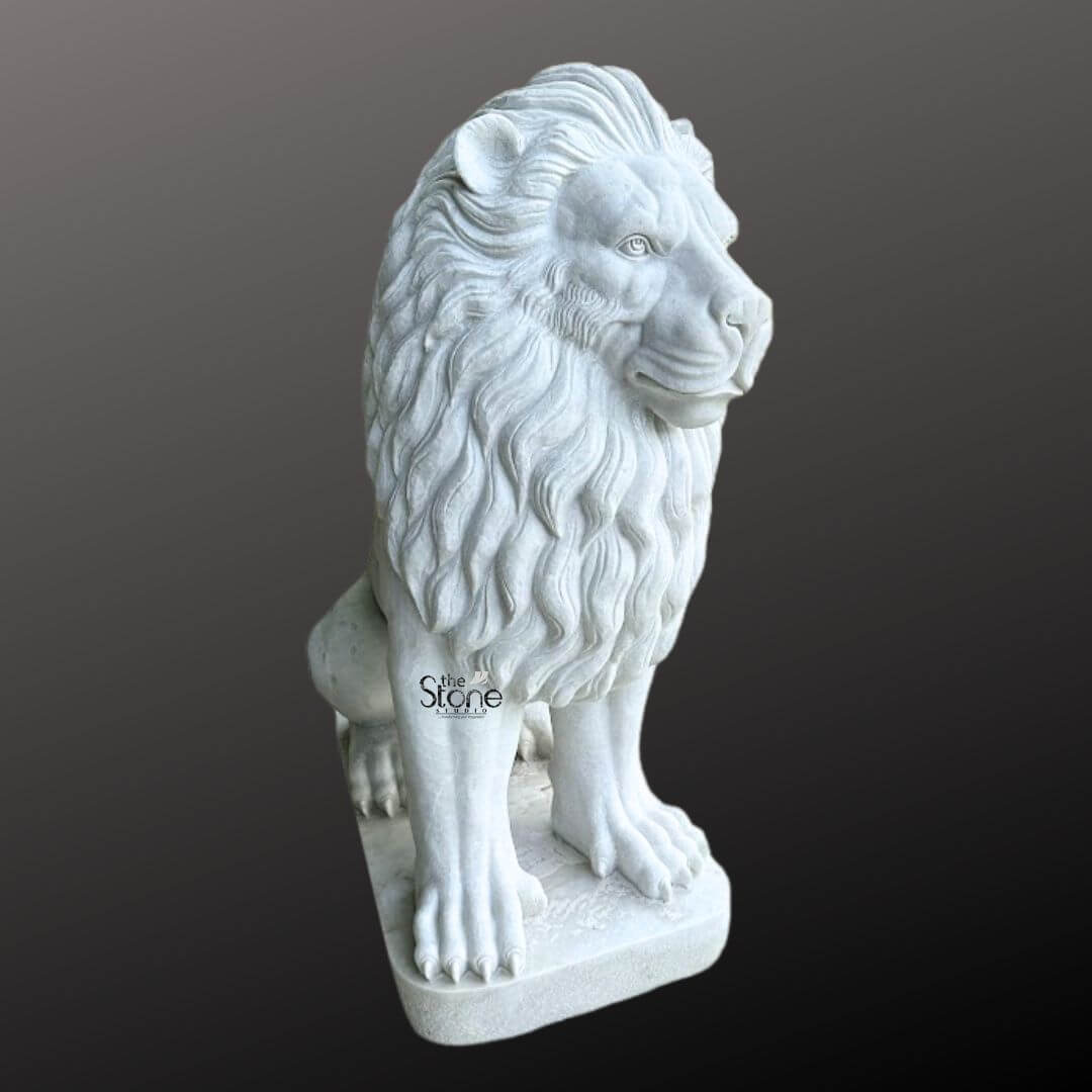 White Marble Lion Statue 5ft 6 A magnificent marble lion statue is prominently displayed in a side profile against a dark gradient background, ideally suited for a gate entrance. The lion is meticulously sculpted in a regal seated position with its powerful body held upright and its head turned to the right gazing intently into the distance with a watchful and majestic demeanor. Its profile reveals a detailed and commanding expression with a strong jawline defined eyes and a prominent nose. The intricate carving brilliantly captures the texture of its flowing voluminous man which cascades around its head neck and shoulders conveying a sense of immense power and dignity perfect for guarding an entrance. The statue is crafted from pristine white marble which exquisitely emphasizes the fine details of the carving from the individual strands within the mane to the robust structure of its paws and the sharp definition of its claws. The smooth, polished surface of the marble subtly reflects ambient light accentuating the contours and musculature of the lion's formidable form. The inherent beauty and purity of the white marble are showcased highlighting the exceptional skill of the artisan in bringing such a formidable creature to life in stone providing an impressive and welcoming presence at a gate. The marble lion statue rests on a sturdy rectangular base also carved from matching white marble providing a solid foundation and integrating seamlessly with the overall design. This elegant sculpture captures the essence of a powerful guardian and a timeless symbol of royalty and strength, making it a captivating subject for an article exploring marble lion statues and their commanding presence when used for enhancing and securing a gate entrance.