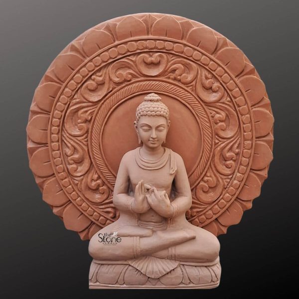 A serene Meditation Buddha statue crafted from off-white sandstone is depicted against a dark neutral background emphasizing its calm and spiritual presence. The Buddha is seated in a classic lotus position with hands gently clasped in Dhyana Mudra the gesture of meditation and contemplation. His eyes are softly closed conveying deep inner peace and enlightenment. The subtle off-white hue of the sandstone highlights the smooth contours of his robes and the serene expression on his face radiating tranquility. Behind the Buddha's head is an exquisitely carved circular halo or prabhamandala featuring intricate floral and traditional Indian motifs. This halo provides a magnificent backdrop symbolizing divine light and spiritual purity and adding a layer of ornate detail to the otherwise minimalist form of the Buddha. The craftsmanship of the halo with its layered patterns and delicate carvings contrasts beautifully with the smooth understated elegance of the main Buddha figure making the entire piece a harmonious blend of simplicity and elaborate design. The base of the statue also carved from the same sandstone features subtle lotus petal detailing further enhancing its sacred symbolism. This image is perfectly suited for an article about Meditation Buddha statues with halos showcasing an ideal piece for home or meditation spaces. The off-white sandstone provides a contemporary yet timeless appeal making it versatile for various decor styles while maintaining its profound spiritual essence. The detailed depiction of the Buddha in meditation coupled with the majestic halo reinforces its value as a focal point for mindfulness peace and spiritual contemplation resonating deeply with the article's focus on creating a serene environment.