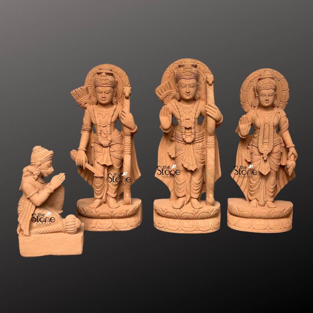 Ram Darbar Idol for Home Temple 2ft 1 A beautifully sculpted 2-foot sandstone Ram Darbar statue set is elegantly displayed against a dark gradient background making it a revered centerpiece for a home temple. The set comprises four figures: Lord Rama Lakshmana Sita and a kneeling Hanuman. Lord Rama stands prominently in the center holding his bow and arrow embodying righteousness and valor. To his left stands Lakshmana also armed and to his right the graceful Sita radiating purity and devotion. Each of these standing figures is adorned with elaborate crowns intricate jewelry and flowing traditional garments all meticulously carved from the warm earthy sandstone. Behind the heads of Rama Lakshmana and Sita circular halo-like structures are intricately carved with traditional patterns further accentuating their divine aura and significance. The craftsmanship is evident in every detail from the serene expressions on their faces to the delicate folds of their attire and the intricate patterns of their ornaments. The sandstone's natural texture and warm hue give the statues an authentic ancient feel enriching their spiritual presence. In the foreground kneeling respectfully is Hanuman carved in a posture of devotion with his hands clasped in reverence. This complete 2-foot sandstone Ram Darbar set captures the essence of this beloved divine assembly representing loyalty devotion and divine love. The harmonious composition and exquisite detailing make this a captivating subject for an article exploring Ram Darbar idols and their importance in home temples.