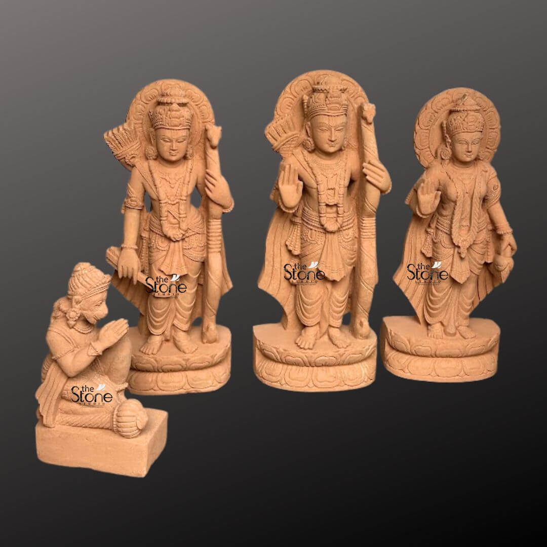 Ram Darbar Idol for Home Temple 2ft 5 A beautifully sculpted 2-foot sandstone Ram Darbar statue set is elegantly displayed against a dark gradient background serving as a prime example for an article on Ram Darbar sandstone statues. The set comprises four figures: Lord Rama Lakshmana Sita and a kneeling Hanuman collectively forming a revered divine assembly. Lord Rama stands prominently in the center holding his bow and arrow embodying righteousness and valor. To his left stands Lakshmana also armed and to his right the graceful Sita radiating purity and devotion with her hand raised in a gesture of blessing. Each of these standing figures is adorned with elaborate crowns intricate jewelry and flowing traditional garments all meticulously carved from the warm earthy sandstone. Behind the heads of Rama, Lakshmana and Sita circular halo-like structures are intricately carved with traditional patterns further accentuating their divine aura and spiritual significance. The craftsmanship is evident in every detail from the serene expressions on their faces to the delicate folds of their attire and the intricate patterns of their ornaments. The sandstone's natural texture and warm hue give the statues an authentic ancient feel enriching their spiritual presence and highlighting the artisans' skill. In the foreground kneeling respectfully is Hanuman carved in a posture of profound devotion with his hands clasped in reverence. The standing figures each rest on multi-layered circular bases featuring delicate lotus petal motifs providing both stability and aesthetic appeal. This complete 2-foot Ram Darbar sandstone statue set captures the essence of this beloved divine assembly representing loyalty devotion and divine love. Its harmonious composition and exquisite detailing make this a captivating subject for an article exploring Ram Darbar statues and their importance in Hindu tradition.