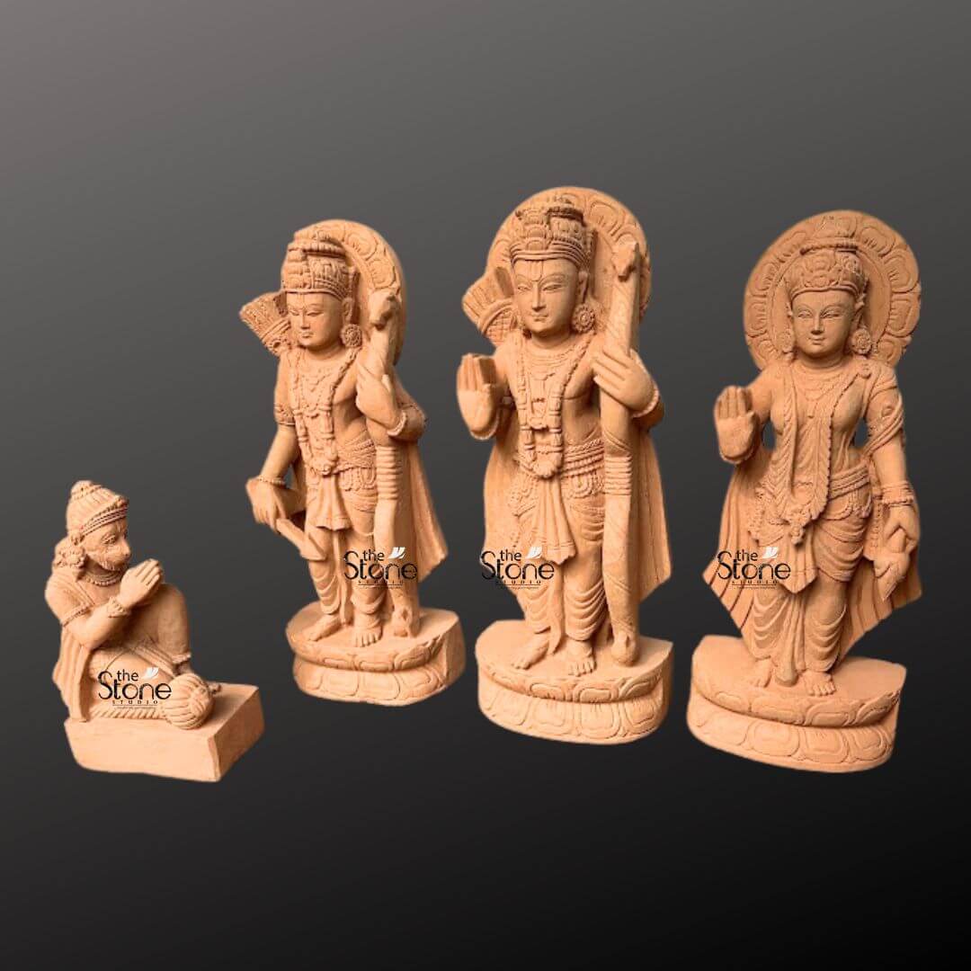 Ram Darbar Idol for Home Temple 2ft 10 A beautifully sculpted 2-foot sandstone Ram Darbar statue set featuring Lord Rama Sita and Hanuman is elegantly displayed against a dark gradient background. The set comprises four figures: Lord Rama Lakshmana Sita and a kneeling Hanuman collectively forming a revered divine assembly. Lord Rama stands prominently holding his bow and arrow embodying righteousness and valor. To his left stands Lakshmana also armed and to his right the graceful Sita radiating purity and devotion with her hand raised in a gesture of blessing. Each of these standing figures is adorned with elaborate crowns intricate jewelry and flowing traditional garments all meticulously carved from the warm earthy sandstone. Behind the heads of Rama, Lakshmana and Sita circular halo-like structures are intricately carved with traditional patterns further accentuating their divine aura and spiritual significance. The craftsmanship is evident in every detail from the serene expressions on their faces to the delicate folds of their attire and the intricate patterns of their ornaments. The sandstone's natural texture and warm hue give the statues an authentic ancient feel, enriching their spiritual presence and highlighting the artisans' skill. In the foreground, kneeling respectfully is Hanuman carved in a posture of profound devotion with his hands clasped in reverence. The standing figures each rest on multi-layered circular bases featuring delicate lotus petal motifs providing both stability and aesthetic appeal. This complete 2-foot sandstone Ram Darbar set depicting Ram, Sita and Hanuman captures the essence of this beloved divine assembly representing loyalty, devotion and divine love. Its harmonious composition and exquisite detailing make this a captivating subject for an article exploring such revered sandstone statues.