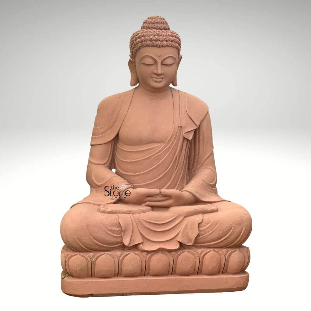 5 Feet Sandstone Buddha Statue for Garden 2 A grand 5-foot meditation Buddha statue meticulously carved from sandstone prominently featured in an article about such sculptures. The entire statue is rendered in the natural reddish-brown hue of sandstone exuding an earthy warm and timeless aesthetic. The Buddha is depicted seated in the full lotus position with both hands gently resting in his lap palms facing upwards in the Dhyana Mudra symbolizing deep contemplation inner peace and spiritual awakening. The robes are elegantly draped over his left shoulder with realistic flowing folds and pleats meticulously carved into the sandstone. These details convey a sense of serenity and the soft texture of fabric adding depth to the sculpture. The Buddha's face is characterized by a profoundly calm and contemplative expression with downcast half-closed eyes a gentle nose and subtle lips embodying a state of complete enlightenment and inner stillness. His tightly curled hair a distinctive iconographic feature is intricately textured and his elongated earlobes are visible symbolizing wisdom and a royal past. The Buddha is seated on a beautifully carved lotus pedestal also made of sandstone with individual lotus petals clearly defined symbolizing purity and spiritual growth. The smooth contours and fine details throughout the entire 5-foot statue emphasize a deep sense of tranquility and spiritual harmony. This sandstone meditation Buddha statue is a powerful representation of peace and reflection making it an ideal centerpiece for meditation spaces large gardens, or spiritual retreats perfectly aligning with the article's focus on its meditative qualities and material.