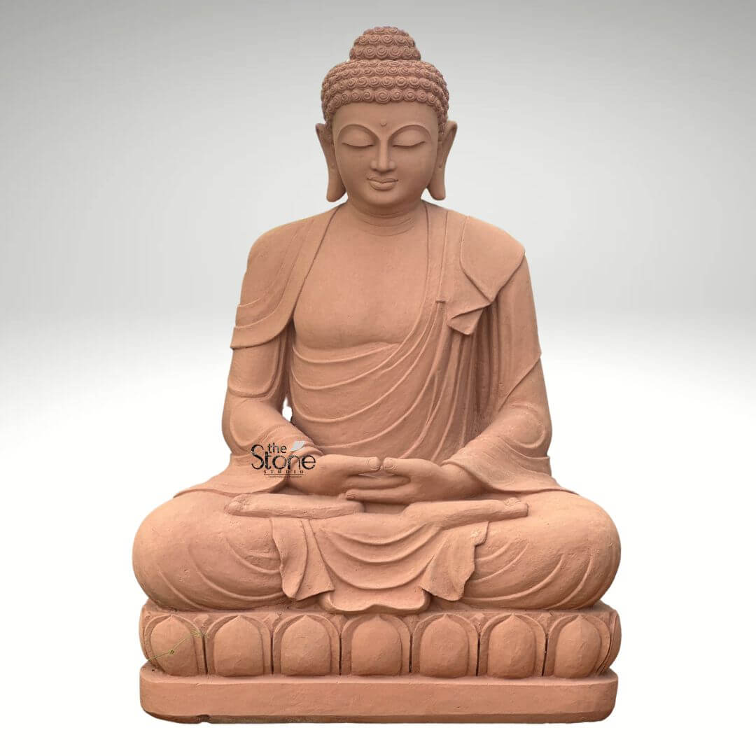 5 Feet Sandstone Buddha Statue for Garden 1 A majestic 5-foot sandstone Buddha statue depicted in a classic meditative posture, ideal for a garden setting as highlighted in the article. The entire sculpture is crafted from natural reddish-brown sandstone, giving it an earthy warm and timeless appearance. The Buddha is seated in the full lotus position (Padmasana), with both hands resting in his lap in the Dhyana Mudra symbolizing deep contemplation and inner peace. The robes are elegantly draped over his left shoulder with realistic flowing folds and pleats meticulously carved into the sandstone conveying a sense of serenity and soft fabric. The Buddha's face is characterized by a calm and contemplative expression with downcast eyes a gentle nose and subtle lips embodying profound enlightenment. His tightly curled hair a distinctive iconographic feature is intricately textured and his elongated earlobes are visible symbolizing wisdom and a royal past. The Buddha is seated on a beautifully carved lotus pedestal also made of sandstone with individual lotus petals clearly defined symbolizing purity and spiritual awakening. The smooth contours and fine details throughout the entire 5-foot statue emphasize a deep sense of tranquility and spiritual harmony. This sandstone Buddha statue is a powerful representation of peace and reflection making it a perfect and durable addition to enhance the aesthetic and spiritual ambiance of any garden or outdoor space as discussed in the accompanying article.