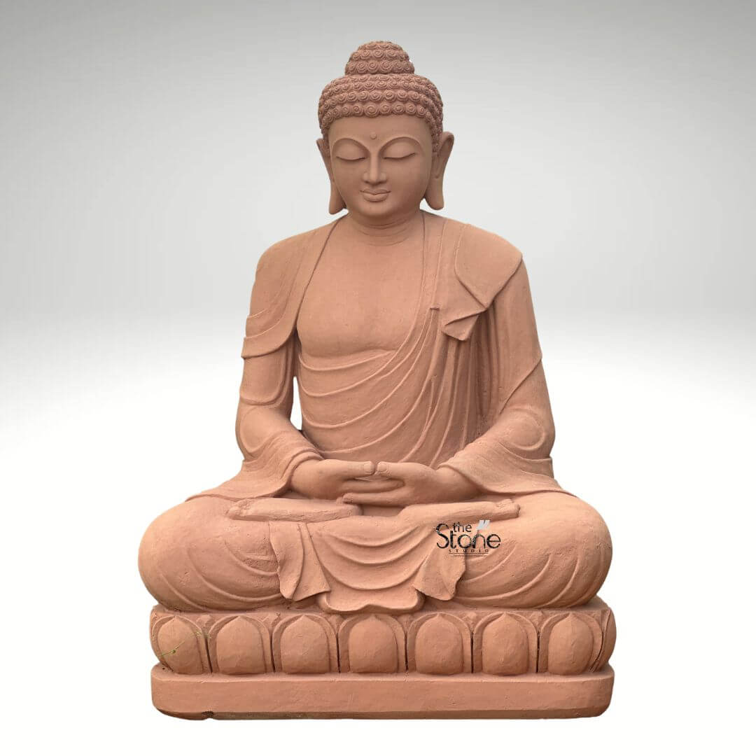 5 Feet Sandstone Buddha Statue for Garden 4 A grand 5-foot sitting Buddha statue meticulously carved from sandstone prominently featured against a neutral background making it an ideal centerpiece for a hom as highlighted in the accompanying article. The entire statue is rendered in the natural reddish-brown hue of sandstone exuding an earthy warm and timeless aesthetic. The Buddha is depicted seated in the full lotus position with both hands gently resting in his lap palms facing upwards in the Dhyana Mudra symbolizing deep contemplation inner peace and spiritual awakening. The robes are elegantly draped over his left shoulder with realistic flowing folds and pleats meticulously carved into the sandstone. These details convey a sense of serenity and the soft texture of fabric adding depth to the sculpture. The Buddha's face is characterized by a profoundly calm and contemplative expression with downcast, half-closed eyes a gentle nose and subtle lips embodying a state of complete enlightenment and inner stillness. His tightly curled haira distinctive iconographic feature is intricately textured and his elongated earlobes are visible symbolizing wisdom and a royal past. The Buddha is seated on a beautifully carved lotus pedestal also made of sandstone with individual lotus petals clearly defined symbolizing purity and spiritual growth. The smooth contours and fine details throughout the entire 5-foot statue emphasize a deep sense of tranquility and spiritual harmony. This sandstone sitting Buddha statue is a powerful representation of peace and reflection making it an ideal spiritual and aesthetic addition to any home, perfectly aligning with the article's focus on its suitability for indoor display and its meditative qualities.