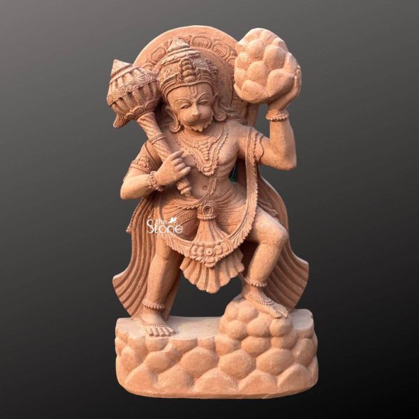 A vibrant 3 Feet Bajrangbali Stone Statue meticulously carved from rich reddish-brown sandstone stands dynamically against a plain dark background highlighting its powerful form and intricate details. This 3 Feet Sandstone Hanuman Statue depicts Lord Hanuman in a heroic active pose ready for action. He holds his formidable gada over his left shoulder symbolizing his immense strength and with his right hand he lifts the Sanjeevani mountain signifying his life-saving feat. The warm earthy tones of the sandstone give the statue a traditional and inviting appearance. Hanuman is richly adorned with finely sculpted traditional attire and extensive ornamentation all meticulously rendered in the sandstone. This includes a regal crown multiple layered necklaces armbands and a detailed dhoti with gracefully flowing fabrics. His expressive monkey-like face with a determined gaze conveys courage and unwavering devotion. Behind his head a simple halo or aureole further accentuates his divine presence while his long flowing tail curves upwards emphasizing his dynamic posture. The visible texture of the sandstone adds an authentic and ancient feel to the entire figure. The statue stands on a textured rocky base also carved from sandstone indicating his heroic act of carrying the mountain. The details of the musculature and the intricate carvings on his jewelry and garments showcase a high level of artistry. The overall composition powerfully conveys Bajrangbali's immense strength courage and selfless service making it an ideal Bajrangbali Stone Statue for inspiring devotion and admiration. This detailed description effectively connects the visual elements of the sandstone sculpture with its spiritual significance and aesthetic qualities, making it a compelling image for an article about such a revered and dynamically posed deity.