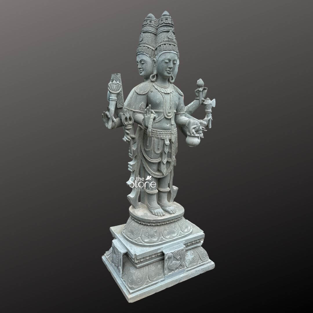 Brahma Stone Statue 7ft 6 A magnificent 7-foot handcrafted Chaturmukhi Brahma Murti sculpted from greystone is presented in a stately slightly oblique front view against a dark plain background emphasizing its grandeur and intricate craftsmanship. The statue depicts Lord Brahma the creator god in a standing posture with his characteristic four heads symbolizing his omnipresence and knowledge. The natural grey tones and subtle textures of the stone lend an ancient and dignified quality to this impressive murti highlighting its detailed carvings. Lord Brahma is meticulously carved with his four serene and contemplative faces each adorned with an elaborate crown and facing the cardinal directions. He is richly adorned with multiple necklaces armlets and a sacred thread all finely detailed. In his multiple hands he holds his traditional attributes including a sruva or rosary a kamandalu and a puskara symbolizing his role in creation and knowledge. His attire is elegantly draped with intricate patterns on his lower garment and decorative elements around his waist. He stands barefoot on a lotus pedestal which in turn rests on a multi-tiered intricately carved base featuring smaller decorative elements and possibly mythical creatures. This 7-foot handcrafted greystone Chaturmukhi Brahma Murti is a profound representation of creation, wisdom and cosmic knowledge making it a powerful and auspicious addition to any temple or significant spiritual space. The exceptional craftsmanship in natural greystone not only makes it a visually striking piece but also imbues it with deep cultural and religious significance. This exquisitely detailed murti serves as a commanding focal point for devotion and prayer radiating positive energy and ancient wisdom to all who venerate it.