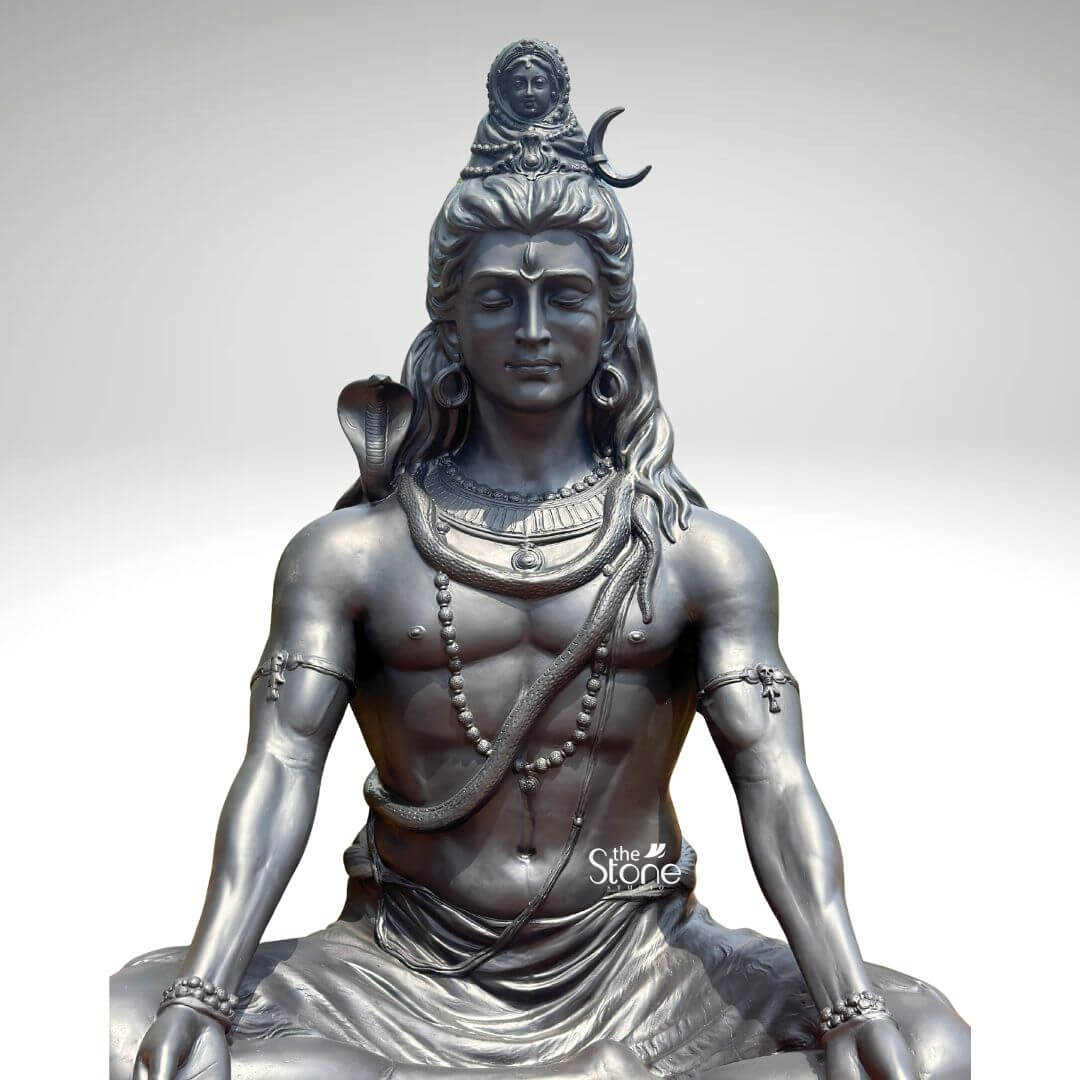 6 Feet Meditating Lord Shiva Statue 9 A magnificent large 6-foot Fibre Shiva Statue finished to resemble dark metal is presented against a clean light background emphasizing its grandeur and spiritual presence specifically designed for temple installation. The statue depicts Lord Shiva in a classic meditative posture exuding an aura of profound tranquility cosmic power and divine wisdom. This impressive large-scale fiber Shiva statue is an inspiring piece ideal as a primary deity for a temple. Lord Shiva's features are sculpted with remarkable detail and serenity: his eyes are half-closed in deep contemplation his long, flowing matted hair is elaborately piled high adorned with a crescent moon and a miniature figure of Goddess Ganga symbolizing the sacred river's descent. A lifelike cobra gracefully coils around his neck and multiple rudraksha bead malas drape across his chest and muscular tors along with other ornate necklaces and armbands. His hands rest gently in his lap in Dhyana Mudra the gesture of meditation while his muscular yet serene physique is subtly defined beneath his draped lower garment. The dark metallic finish of the fiber material captures the subtle play of light and shadow highlighting every intricate detail of the carving from the texture of his hair to the smooth contours of his skin giving it a powerful contemplative presence. This large 6-foot Fibre Shiva Statue is a powerful representation of the ultimate reality the destroyer of evil and the source of all yoga and meditation perfectly suited for impactful temple installation. The exceptional artistry in fiber allows for such intricate detailing and a commanding yet peaceful presence making it a visually striking and spiritually significant artifact. This statue not only serves as a focal point for devotion and meditation but also as a majestic piece of art that radiates peace strength and cosmic energy enriching any sacred space with its profound cultural and religious resonance truly embodying the essence of Lord Shiva for worship.