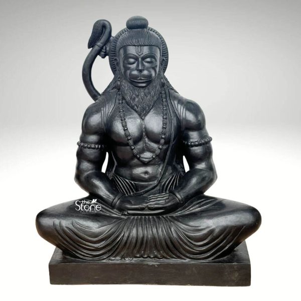 A profound 3 Feet Meditating Hanuman Statue meticulously carved from dark blackstone often referred to as black granite for its similar appearance and durability is presented against a clean light background highlighting its serene yet powerful presence. This 3 Feet Blackstone Hanuman Statue depicts Lord Hanuman in a deep meditative state seated in a cross-legged lotus position. His eyes are gently closed conveying profound inner peace and spiritual focus making it a perfect Meditating Hanuman Statue Black Granite for contemplation. The smooth polished surface of the blackstone gleams emphasizing the muscular definition of his physique and the delicate details of his attirr. Hanuman is adorned with traditional elements a topknot on his head a sacred thread across his chest and beaded necklaces. His distinct monkey-like facial features are rendered with great detail expressing devotion and tranquility even in meditation. A prominent curved tail arches elegantly behind his right shoulder a signature attribute of Hanuman. His hands are placed in his lap in a meditative gesture further reinforcing his state of deep concentration. The subtle gleam of the blackstone adds to the statue's majestic and ancient feel reflecting light beautifully while maintaining its dark, commanding presence. The statue rests on a solid rectangular blackstone base providing a sturdy and dignified foundation. The intricate carving of the dhoti shows flowing pleat adding texture and realism to the figure. The overall composition of this 3 Feet Blackstone Hanuman Statue powerfully conveys Hanuman's immense strength tempered by his unwavering devotion and spiritual discipline. This detailed description effectively connects the visual elements of the blackstone sculpture with its spiritual significance and aesthetic qualities making it an ideal representation for an article about a Meditating Hanuman Statue Black Granite.
