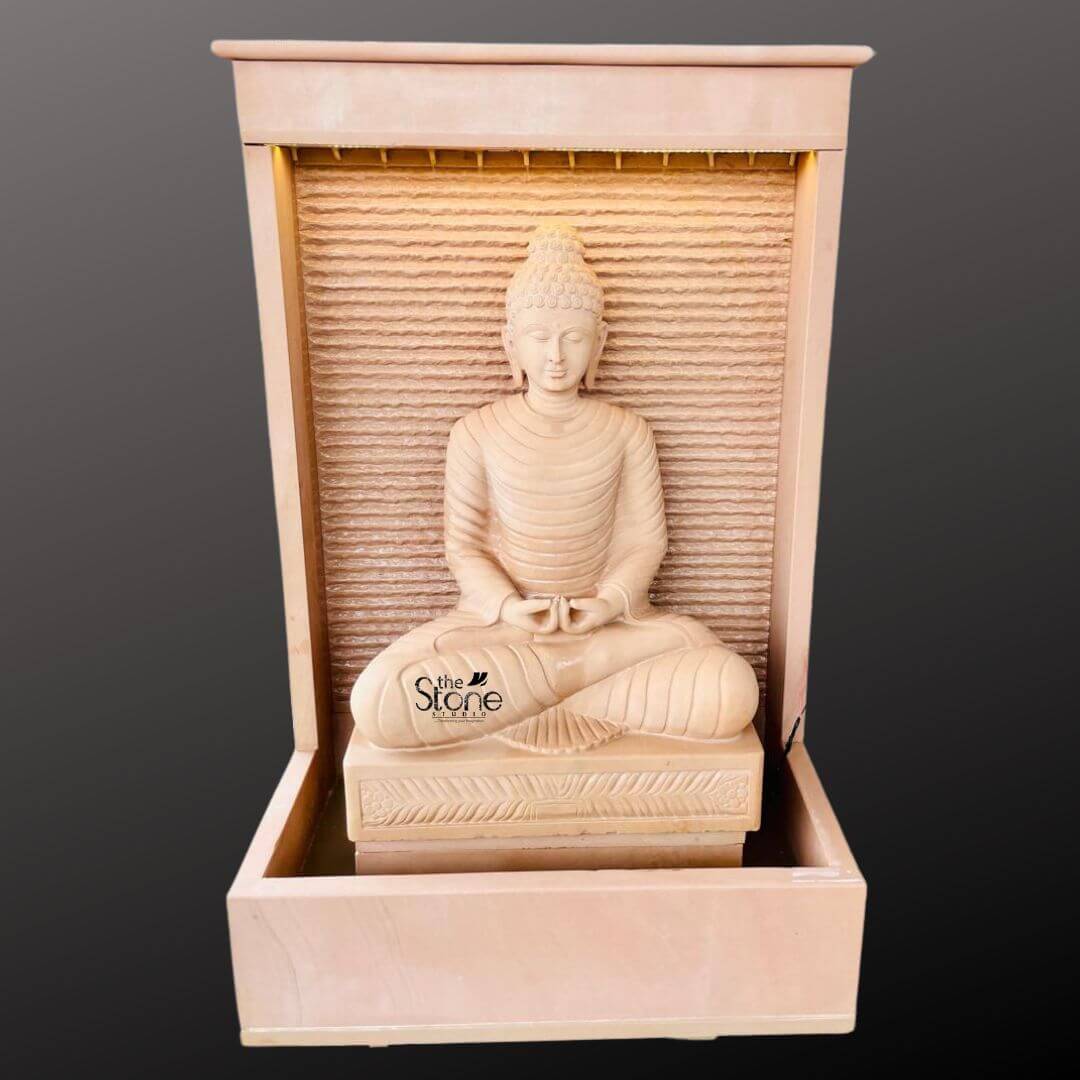 Outdoor Buddha Stone Water Fountain 4.5ft 4 A majestic hand-carved four-and-a-half-foot tall Buddha statue serves as the serene centerpiece of an elegant garden water fountain presented in a clean studio setting against a dark grey background. The entire fountain structure including the statue is crafted from beautiful light beige-to-grey off-white sandstone exhibiting a natural textured porous surface that enhances its organic earthy feel. The Buddha is depicted in a traditional seated meditative pose on a raised pedestal with legs crossed in a full lotus position and hands resting in the lap in the dhyana mudra of deep contemplation. His facial expression is calm and compassionate with downcast eyes a gentle smile and tightly curled hair leading to a cranial ushnisha all rendered with exquisite craftsmanship and flowing yet subtle carved folds of his monastic robes. The statue is enclosed within a monolithic frame-like sandstone structure creating a stunning wall-fountain design. Water is subtly distributed to flow like a gentle curtain down the textured horizontally-ribbed back panel directly behind the Buddha pooling into the large monolithic rectangular basin at the base. The sound of the cascading water adds a tranquil multi-sensory dimension to the visual stillness of the statue creating a peaceful and meditative atmosphere. The warm earthy hue of the sandstone contrasts beautifully with the cool dark background making the statue pop and highlighting its intricate details and substantial presence. This four-and-a-half-foot Buddha Fountain Off White Sandstone Statue is an ideal illustration for an article discussing Garden Buddha Fountain in Sandstone demonstrating how such a piece can transform a garden patio or courtyard into a peaceful sanctuary. Its large scale ensures it becomes a commanding focal point while the durable sandstone construction makes it suitable for enduring outdoor elements as a long-lasting garden ornament. The combination of sacred art with the gentle movement of water embodies a sense of harmony and spirituality, perfect for creating a dedicated space for meditation reflection and aesthetic appreciation in any outdoor living area. The detailed carving and harmonious integration of elements highlight its value as both a decorative and a meaningful addition to a modern landscape.