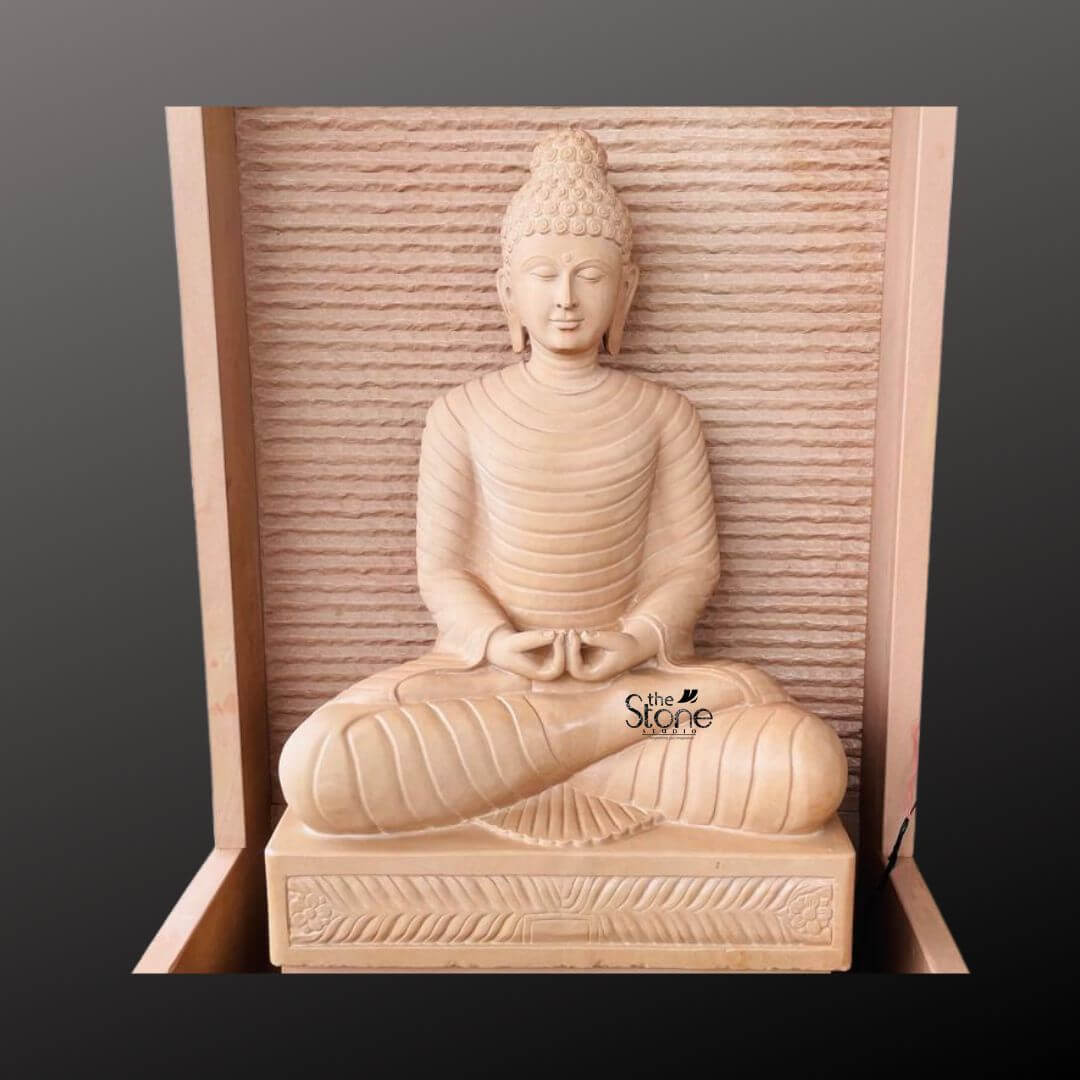 Outdoor Buddha Stone Water Fountain 4.5ft 6 A magnificent, hand-carved four-and-a-half-foot tall Buddha statue sits as the serene centerpiece of an elegant stone water fountain presented in a clean studio setting against a dark grey background. The entire fountain structure including the statue is crafted from beautiful light beige-to-grey off-white sandstone exhibiting a natural textured porous surface that enhances its organic earthy feel. The Buddha is depicted in a traditional seated meditative pose on a raised pedestal with legs crossed in a full lotus position and hands resting in the lap in the dhyana mudra of deep contemplation. His facial expression is calm and compassionate with downcast eyes a gentle smile and tightly curled hair leading to a cranial ushnisha all rendered with exquisite craftsmanship and flowing yet subtle carved folds of his monastic robes. The statue is enclosed within a monolithic frame-like sandstone structure creating a stunning wall-fountain design. Water is subtly distributed to flow like a gentle curtain down the textured horizontally-ribbed back panel directly behind the Buddha, pooling into the large monolithic rectangular basin at the base. The sound of the cascading water adds a tranquil multi-sensory dimension to the visual stillness of the statue creating a peaceful and meditative atmosphere. The warm, earthy hue of the sandstone contrasts beautifully with the cool dark background making the statue pop and highlighting its intricate details and substantial presence. This four-and-a-half-foot Buddha Fountain Off White Sandstone Statue is an ideal illustration for an article discussing Handcrafted Buddha Stone Fountains demonstrating how such a piece can transform an indoor or outdoor space into a peaceful sanctuary. Its large scale ensures it becomes a commanding focal point, while the durable sandstone construction makes it suitable for enduring outdoor elements as a long-lasting garden ornament. The combination of sacred art with the gentle movement of water embodies a sense of harmony and spirituality perfect for creating a dedicated space for meditation reflection and aesthetic appreciation in any living area. The detailed carving and harmonious integration of elements highlight its value as both a decorative and a meaningful addition to a modern landscape.
