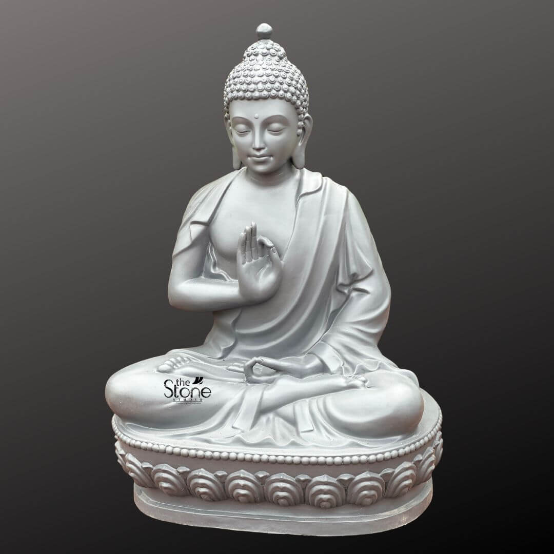 Seated Buddha Statue in Vitarka Mudra 3.5ft 7 A magnificent 3.5-foot Vitarka Mudra Buddha Sculpture crafted from durable fiber is presented against a uniform dark grey background providing a clear and focused view. The statue beautifully depicts Buddha in a serene meditative posture specifically the full lotus position symbolizing deep concentration and spiritual enlightenment. The most prominent feature central to the article's topic is his right hand raised in the Vitarka Mudra the thumb and index finger touch to form a circle while the other fingers are extended upwards gesture vividly conveying the act of teaching intellectual discussion and the transmission of Dharma. His left hand rests gently in his lap palm upwards signifying contemplation and receptivity. The statue's consistent light grey finish offers a contemporary and elegant aesthetic allowing the subtle contours and fine details of the sculpture to be clearly appreciated. The Buddha's facial features are exquisitely carved radiating profound peace wisdom and the calm assurance of a teacher. His eyes are gently closed or downcast suggesting deep introspection and a serene state of mind characteristic of a figure steeped in meditation and prepared to share insights. A subtle serene smile graces his lips and his elongated earlobes a traditional symbol in Buddhist iconography subtly reference his detachment from worldly possessions. His head is adorned with tightly coiled hair culminating in the ushnisha the symbolic cranial protuberance that signifies his supreme spiritual knowledge and enlightenment. The flowing drapery of his robes is expertly rendered with soft folds and graceful lines conveying the lightness and texture of fabric further enhancing the statue's peaceful and elegant form. The Buddha is seated upon a beautifully sculpted double-lotus pedestal with each petal intricately carved symbolizing purity spiritual growth and the emergence of enlightenment from the mundane. This impressive 3.5-foot Buddha Fibre sculpture with its clear depiction of the Vitarka Mudra embodies profound spiritual meaning and artistic excellence. Its significant size and detailed craftsmanship make it a perfect centerpiece to inspire tranquility reflection and the pursuit of wisdom in any indoor or outdoor living space aligning perfectly with the article's focus on a Buddha sculpture specifically showcasing the Vitarka Mudra.