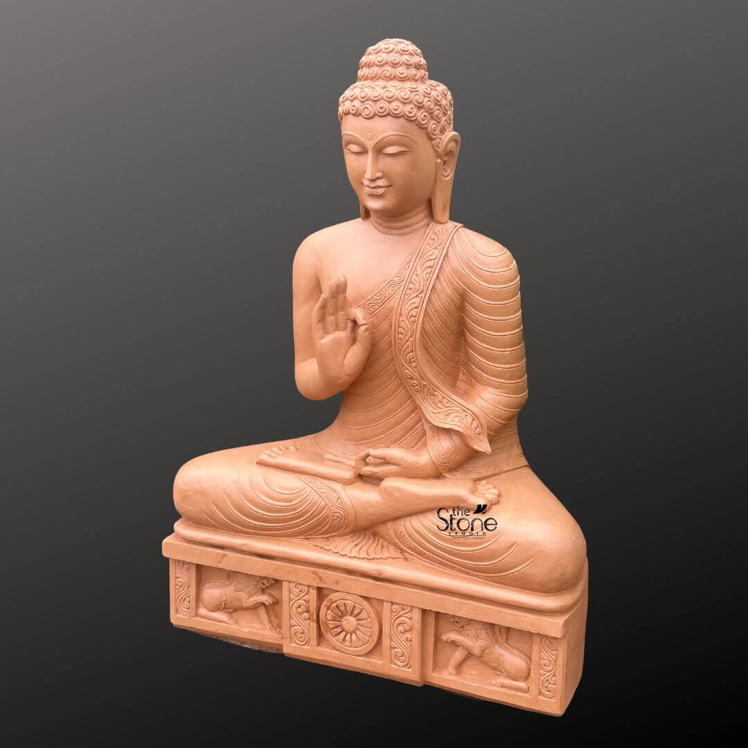 A full-view three-quarter perspective photograph presents a magnificent 4-foot tall Brown Stone Meditation Buddha Statue meticulously hand-carved and designed to be an imposing focal point for a dedicated meditation space or garden. The statue is carved from warm textured brown sandstone showcasing a natural artisanal quality across its entire surface. It is seated in the traditional vajra lotus position embodying profound peace and deep meditation. The Buddha is draped in intricately carved monastic robes with the fabric folds and a decorative patterned border clearly defined on the left shoulder. The figure's face is serene with eyes half-closed in contemplation and a gentle smile. The statue sits upon a substantial carved rectangular pedestal that is an integral part of the 4-foot structure. This plinth is adorned with detailed bas-relief carvings on its front face. In the center a prominent Dharma Chakra is flanked by sculpted lions ancient symbols of the Buddha's royalty and the spread of his teachings. The hands are held in the Vitarka Mudra with the right hand raised and the thumb and index finger forming a circle symbolizing the transmission of teachings and intellectual discussion while the left hand rests in the lap in the gesture of meditation. This 4-foot Sandstone Buddha statue for meditation is an exceptional piece of spiritual art. The substantial height ensures it becomes a dominant and inspiring presence in any setting. The warm brown sandstone is durable for both indoor and outdoor environments and weathers gracefully over time enhancing its ancient appearance. The intricate carvings from the curls of the ushnisha to the figures on the base demonstrate a high level of craftsmanship. The statue's posture and mudra convey a message of tranquility and wisdom making it a perfect aid for creating a peaceful sanctuary. The lighting is even and directional highlighting every detail of the carving against a neutral dark grey background.