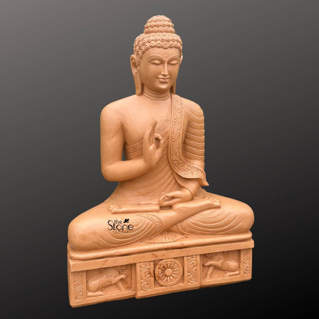 A three-quarter view studio photograph presents a magnificent 4-foot tall Sitting Buddha Statue meticulously hand-carved from warm natural sandstone. The statue is seated in the traditional vajra lotus position embodying profound peace and deep meditation. The Buddha is draped in intricately carved monastic robes, with the fabric folds and a decorative patterned border clearly defined on the left shoulder. The figure's face is serene with eyes half-closed in contemplation and a gentle compassionate smile capturing the essence of enlightenment. The statue sits upon a substantial carved rectangular pedestal that is an integral part of the entire 4-foot structure. This plinth is adorned with detailed bas-relief carvings on its front face. In the center a prominent Dharma Chakra is flanked by sculpted lions ancient symbols of the Buddha's royalty and the spread of his teachings. The entire plinth adds to the statue's monumental presence and cultural authenticity. The natural sandstone exhibits a rich textured and slightly porous surface, showcasing the unique earthy color variations and natural grain inherent to the stone which would complement both indoor and outdoor environments. This 4-foot Sitting Buddha Statue in Natural Sandstone is an exceptional piece of spiritual art. The substantial height ensures it will be a dominant and inspiring presence in any setting whether it's a garden meditation room or grand living area. The intricate carvings from the tight curls of the ushnisha to the figures on the base demonstrate a high level of craftsmanship and devotion. The warm durable sandstone material weathers gracefully over time enhancing its ancient and serene appearance. The statue's posture and mudra convey a message of tranquility and wisdom making it a perfect addition to create a peaceful sanctuary. The lighting is even and directional highlighting every detail of the carving against a neutral dark grey background.